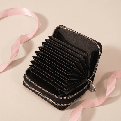 Portefeuille femme compact zippé grande capacité en cuir synthétique noir ouvert Serenya avec ruban rose poudré — Novaleor