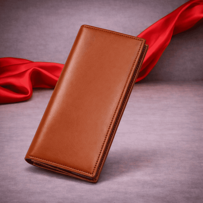 Portefeuille long en cuir marron fermé posé sur fond gris avec voile rouge | Novaleor