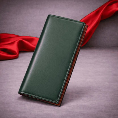 Portefeuille long en cuir vert fermé posé sur fond gris avec voile rouge | Novaleor